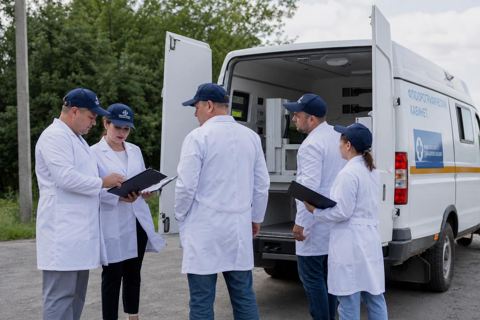 Группа медицинских работников готовит передвижной флюорографический кабинет к выезду в российском регионе